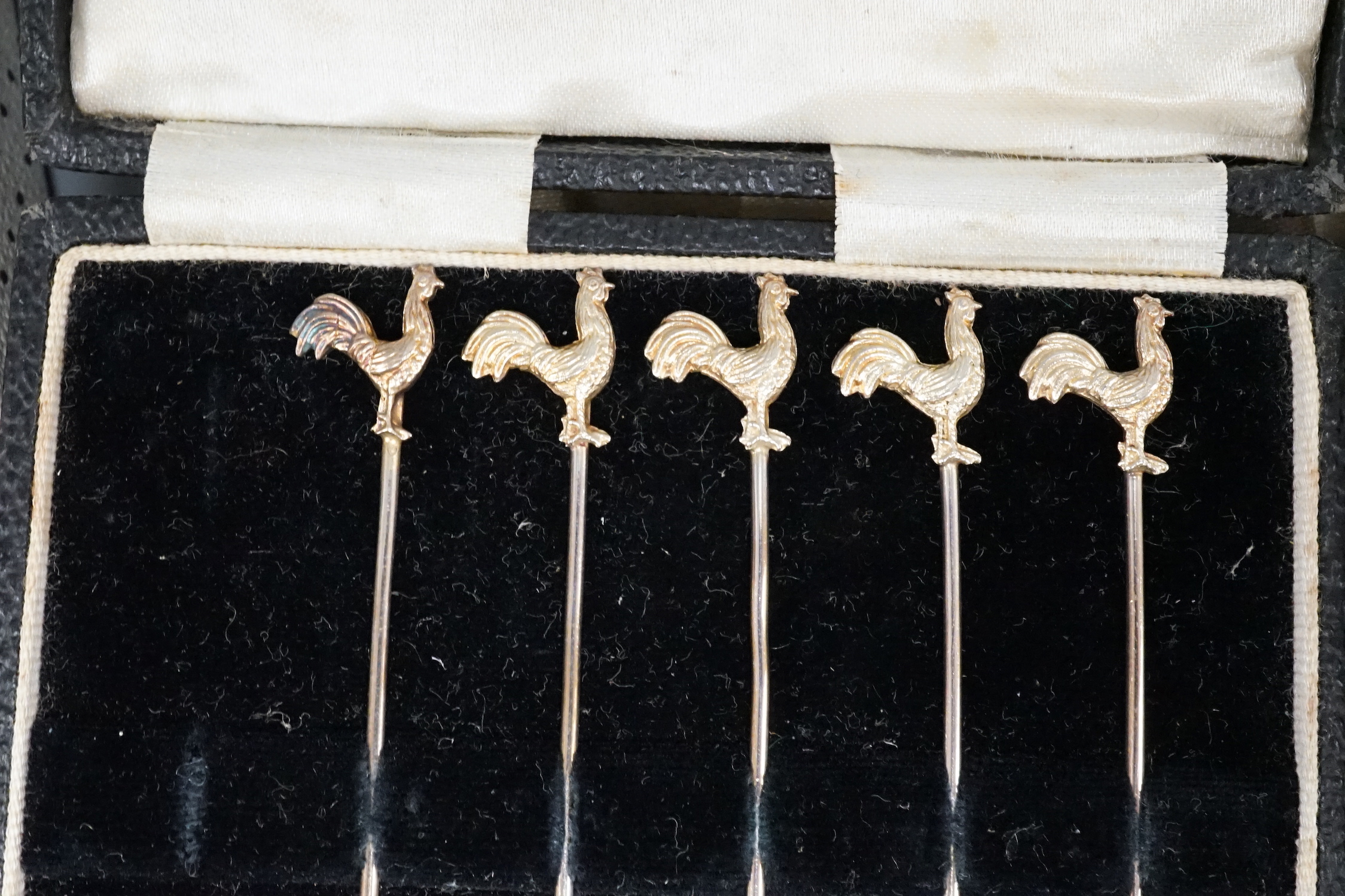 Three cased sets including silver cocktail sticks, two boxed bread knives and a sterling ladle.